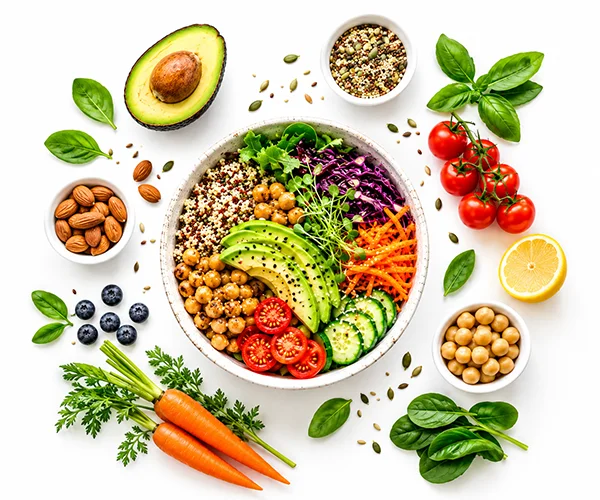 Vegan food bowl with fresh vegetables, avocado, chickpeas, quinoa, carrots, tomatoes, cucumber, leafy greens, and herbs